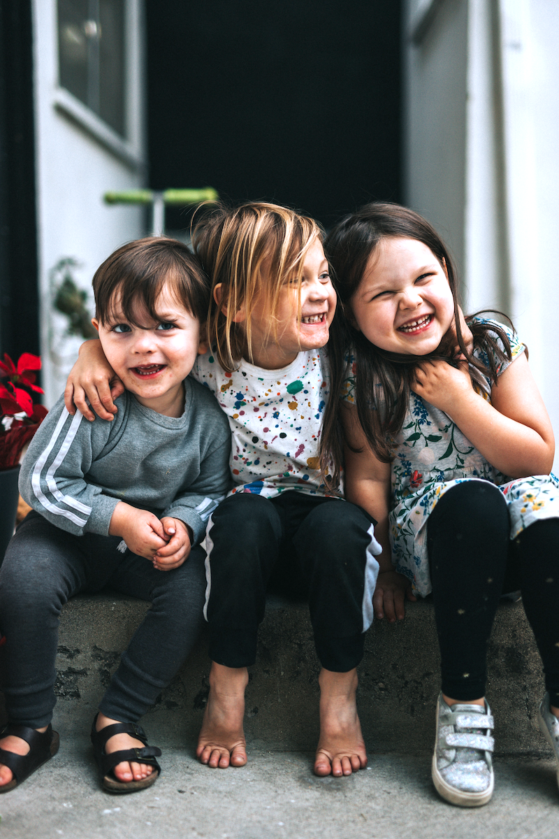 Three kids hugging and laughing