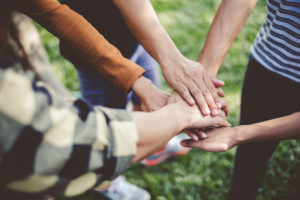 Adults stacking hands together