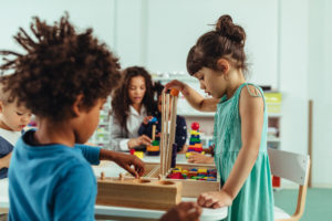 Preschool children and teacher with table toys